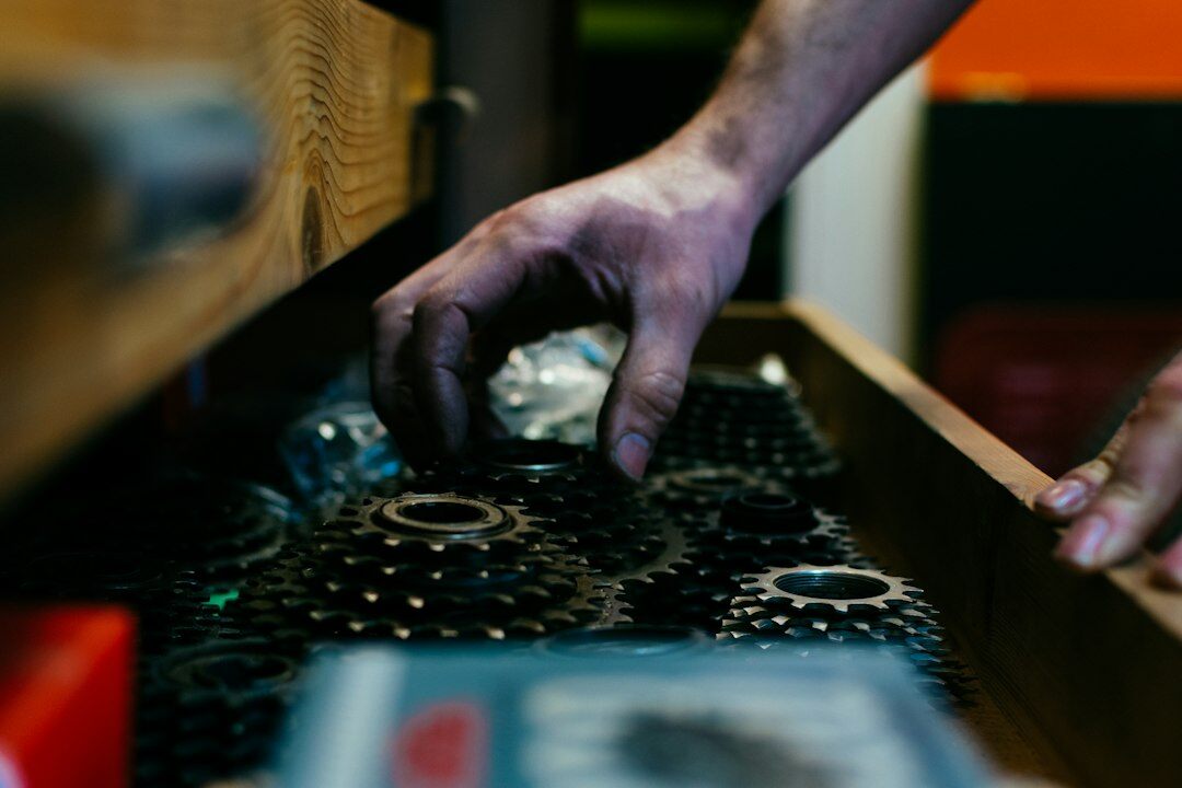 Close-up of hands assembling mechanical gears on a workbench