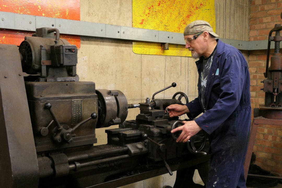 Young engineering student working on a mechanical part in a workshop